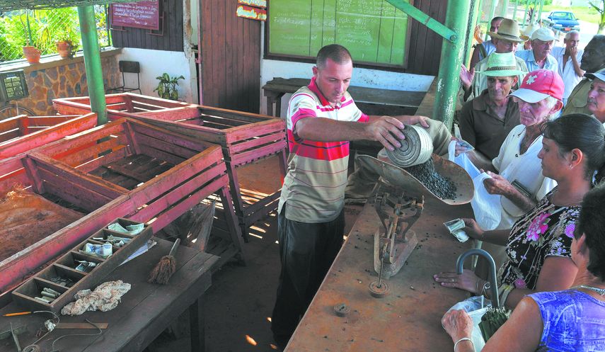 Varias personas hacen cola para obtener una pequeña cantidad de frijoles.&nbsp;
