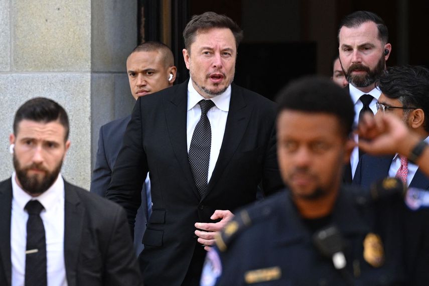 El multimillonario Elon Musk custodiado por su equipo de seguridad.