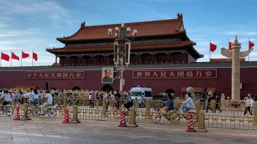 Residentes pasan frente a una camioneta de la policía estacionada junto a la Puerta de Tiananmen, en Beijing, el domingo 4 de junio de 2023.