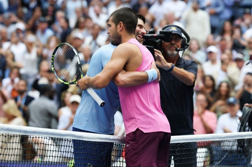 El español Carlos Alcaraz y el serbio Novak Djokovic (izq.) se abrazan en la red tras la victoria de Alcaraz en su partido de semifinales individuales masculino de tenis en el día trece del torneo de tenis US Open en el Centro Nacional de Tenis Billie Jean King de la USTA en la ciudad de Nueva York, el 5 de septiembre de 2025.
