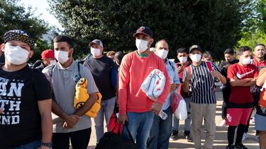 Migrantes llevan mantas de la Cruz Roja tras arribar en autobús a Union Station, cerca del Capitolio, desde Texas.