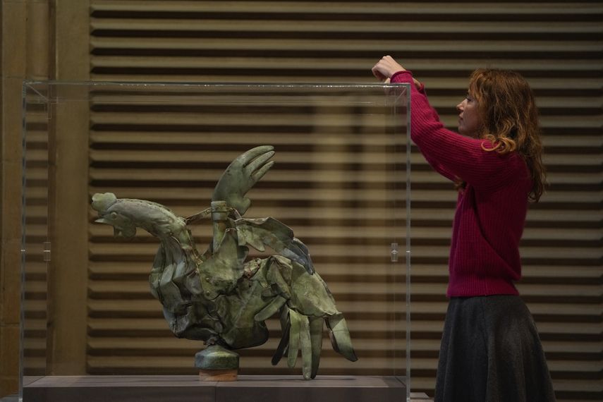 La curadora a cargo de la Galería de Molduras en la Ciudad de la Arquitectura y el Patrimonio, Isabelle Marquette, coloca una caja de vidrio en torno del gallo que coronaba el chapitel de la catedral de Notre-Dame, París, el 15 de diciembre de 2023.