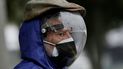 Un hombre vestido con un protector facial completo y una máscara doble para evitar el contagio del COVID-19 espera su turno para ser vacunado, afuera de un centro de vacunación del Instituto del Seguro Social en Quito, Ecuador, el jueves 6 de mayo de 2021