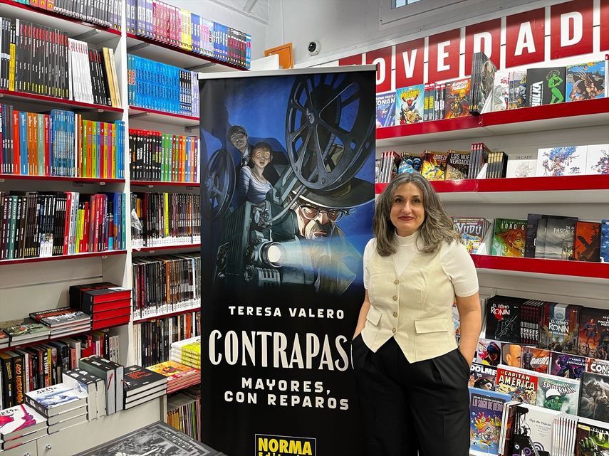 La escritora Teresa Valera posa con el cartel del libro Contrapaso. Mayores con repartos en una rueda de prensa.