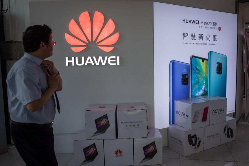 Un hombre se ajusta la corbata en una tienda de Huawei,en Pekín (China).
