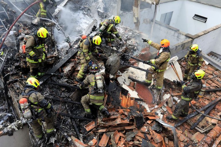 Bomberos trabajan en el lugar del accidente de una avioneta que cayó sobre casas en una zona residencial de Medellín, Colombia, el lunes 21 de noviembre de 2022. 