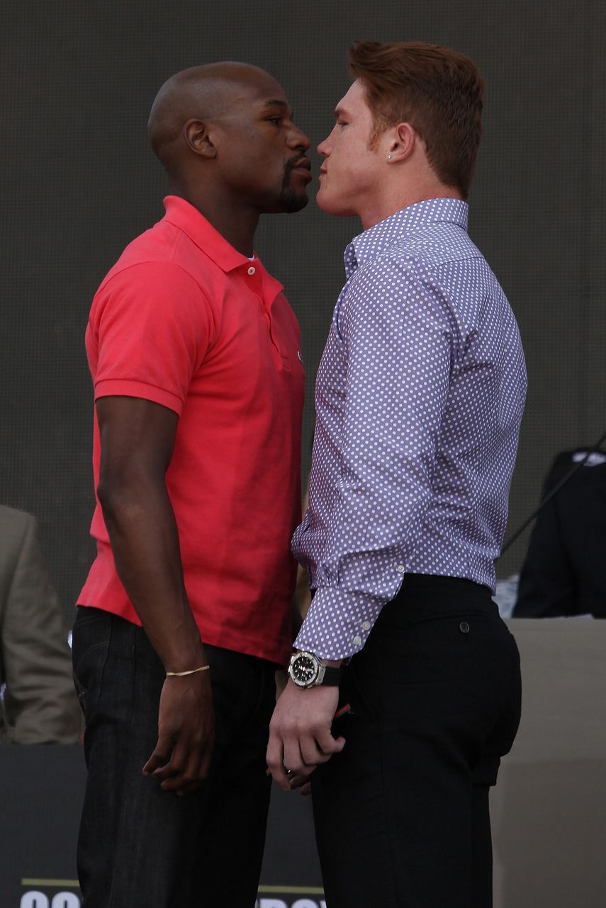 El mexicano Saúl Canelo Álvarez (der.) y el estadounidense Floyd Mayweather (izq.) posan en un acto promocional de su pelea el 30 de junio de 2013.