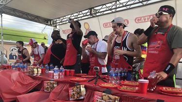 Geoffrey Esper, al centro, con pulover blanco, ganó el premio El Croquetazo en el Carnaval Calle Ocho, de Miami al comerse 154 croquetas en ocho minutos.