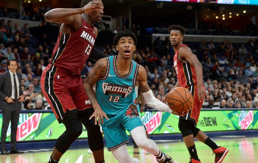 Ja Morant, base de los Grizzlies de Memphis, avanza ante Bam Adebayo, del Heat de Miami, en el encuentro del lunes 16 de diciembre de 2019