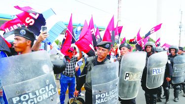 Miembros de la Policía Nacional establecen un cordón de seguridad contra manifestantes.