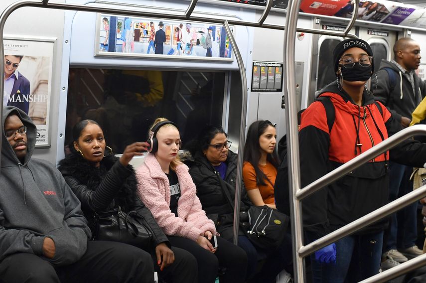 Una persona viaja con un tapabocas en un tren del Metro de Nueva York.