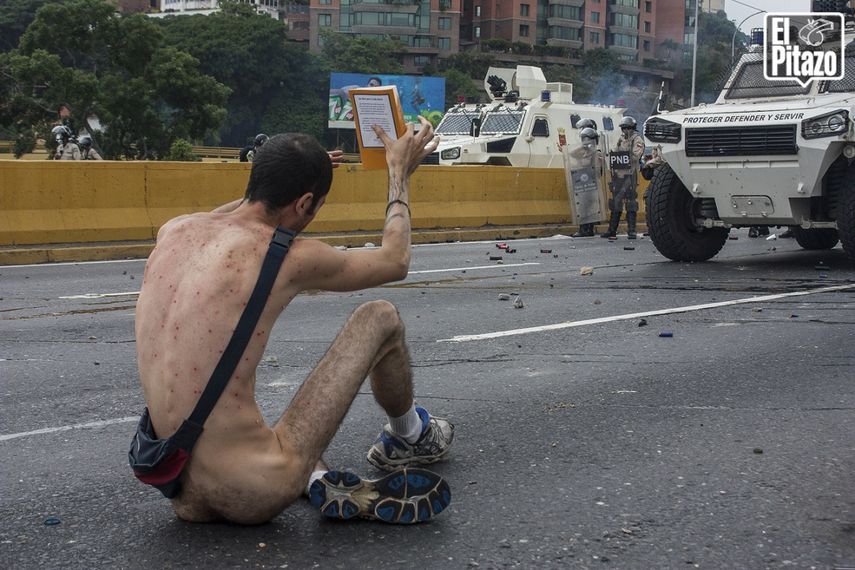 Un&nbsp;hombre&nbsp;protesta&nbsp;desnudo y con una Biblia en las manos el jueves 20 de abril de 2017, en Caracas, Venezuela.