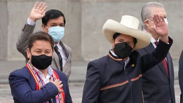El presidente peruano Pedro Castillo, a la derecha, saluda junto al primer ministro Guido Bellido, a la izquierda, y los miembros de su gabinete en el palacio de gobierno.