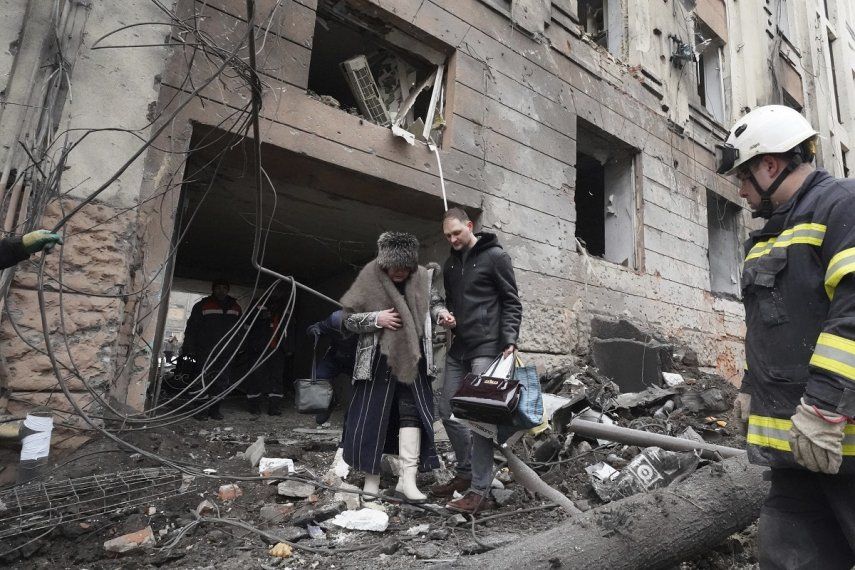 Un hombre ayuda a una mujer a salir de un edificio residencial alcanzado por un cohete ruso en el centro de Járkiv, Ucrania, el domingo 5 de febrero de 2023.&nbsp;