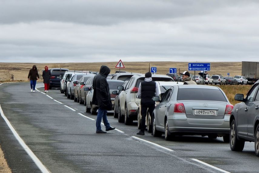 La gente camina junto a sus automóviles haciendo fila para cruzar la frontera de Rusia con Kazajistán en el paso fronterizo de Mariinsky, a unos 400 kilómetros (250 millas) al sur de Chelyabinsk, Rusia, el martes 27 de septiembre de 2022.