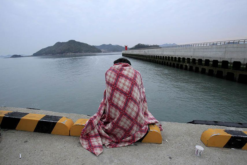 Una persona espera noticias de un familiar desaparecido en un puerto de Jindo, Corea del Sur, el miércoles 16 de abril de 2014.