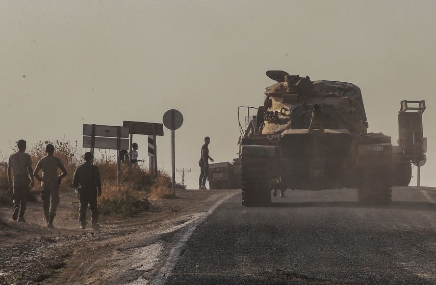 Un tanque de las fuerzas turcas es conducido a su nueva posición tras ser transportado por un camión en un camino hacia la frontera con Siria, en la provincia Sanliurfa, Turquía, el lunes 14 de octubre de 2019. 