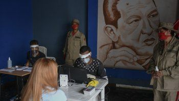 NOTICIA DE VENEZUELA  - Página 43 Personal-del-consejo-nacional-electoral-cne-equipo-protector-del-coronavirus-revisa-archivos-caracas-venezuela-miras-las-elecciones-legislativas-del-6-diciembre-detras-suyo-hay-una-imagen-hugo-chavez