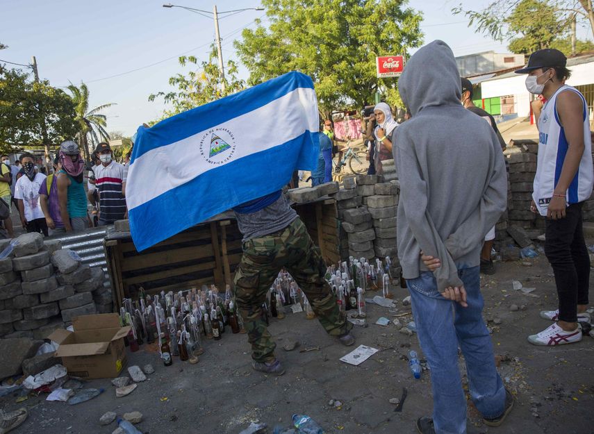 Varios jóvenes protestan hoy, domingo 22 de abril de 2018, durante el quinto día de manifestaciones en contra de una reforma a la seguridad social, en Managua (Nicaragua).&nbsp;