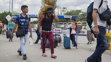 Un hombre carga un gran fardo a la espalda, con una cinta en la frente, mientras trabaja como lomo taxista, o porteador, en la frontera entre Cúcuta, Colombia, y Venezuela, el viernes 20 de septiembre de 2019. 