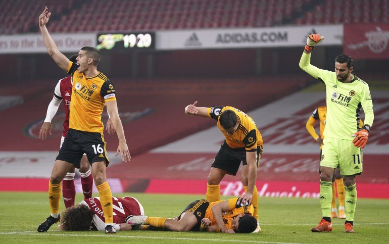 Los jugadores piden auxilio luego del choque de cabezas entre David Luiz de Arsenal (a la izquierda) y Raúl Jiménez de Wolverhampton (derecha) durante el partido de la Liga Premier inglesa, el domingo 29 de noviembre de 2020, en Londres. 