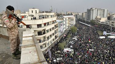 Un guardia apunta a manifestantes en Teherán.