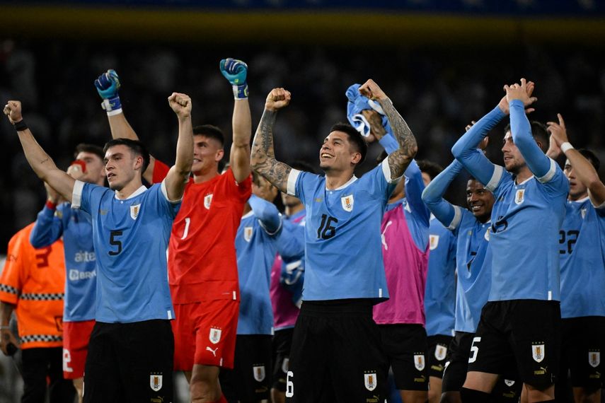 :  El mediocampista uruguayo Manuel Ugarte (i), el defensor Mathías Olivera (i) y el mediocampista Federico Valverde (i) celebran después de derrotar a Argentina durante el partido de fútbol clasificatorio sudamericano para la Copa Mundial de la FIFA 2026