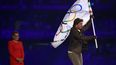 El actor estadounidense Tom Cruise sale con la bandera olímpica frente a la alcaldesa de Los Ángeles, Karen Bass, y a la gimnasta estadounidense Simone Biles, durante la ceremonia de clausura de los Juegos Olímpicos de París 2024 en el Stade de France, en Saint-Denis, en las afueras de París, el 11 de agosto.