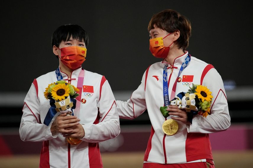 Las chinas Shanju Bao (izquierda) y Tianshi Zhong celebran su oro olímpico en velocidad por equipos en los Juegos de Tokio
