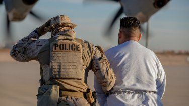 Un miembro del ejército de Estados Unidos traslada a un inmigrante con récord criminal para su deportación