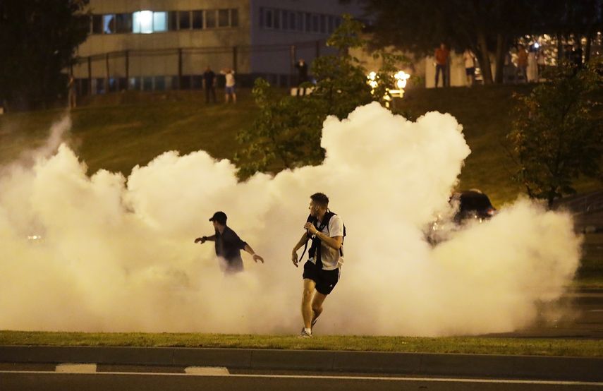 Manifestantes corren en medio del humo durante una protesta el domingo 9 de agosto de 2020 tras las elecciones presidenciales, en Minsk, Bielorrusia.&nbsp;