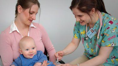 Una trabajadora de la salud administra vacuna a bebé.