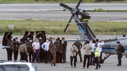 El presidente de Colombia, Iván Duque (izq.), Camina rodeado de guardaespaldas cerca del helicóptero presidencial en la pista del Aeropuerto Internacional Camilo Daza luego de que fuera alcanzado por disparos en Cúcuta, Colombia, el 25 de junio de 2021.&nbsp;&nbsp; &nbsp;