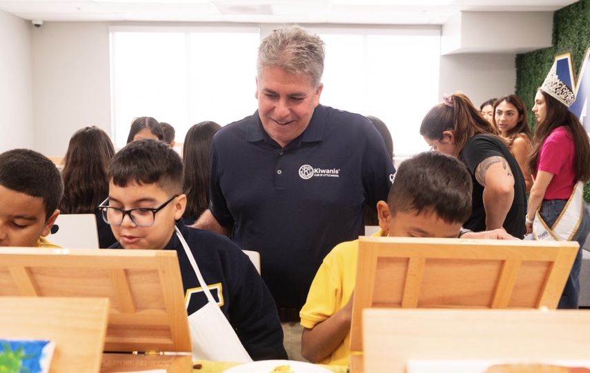 Thomas Falcón, presidente del Club Kiwanis de la Pequeña Habana, comparte con niños en la actividad.