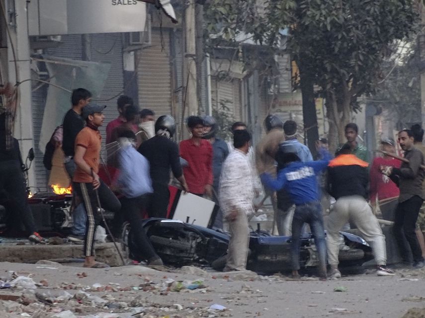 Una turba ataca una tienda y da&ntilde;a veh&iacute;culos durante un brote de violencia entre dos grupos en Nueva Delhi, India, el martes 25 de febrero de 2020.