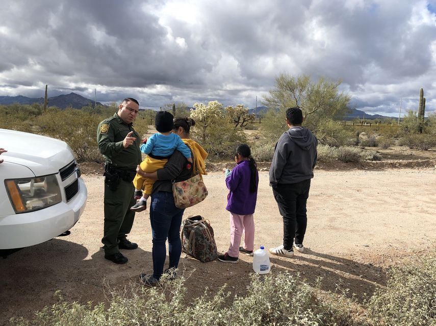 Registro del portavoz de la Patrulla Fronteriza, Daniel Hernández (i), al hablar con una inmigrante hondureña, tras entregarse junto a sus tres hijos de 2, 9 y 14 años, en la frontera de Arizona con México.