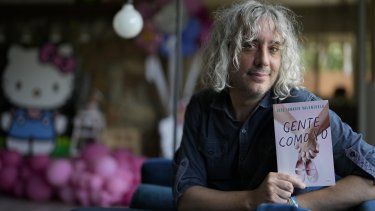 El escritor José Ignacio Valenzuela posa con su más reciente libro Gente como yo el jueves 6 de abril de 2023, en la casa donde vive con su pareja y su hija en Palmetto Bay, Florida.