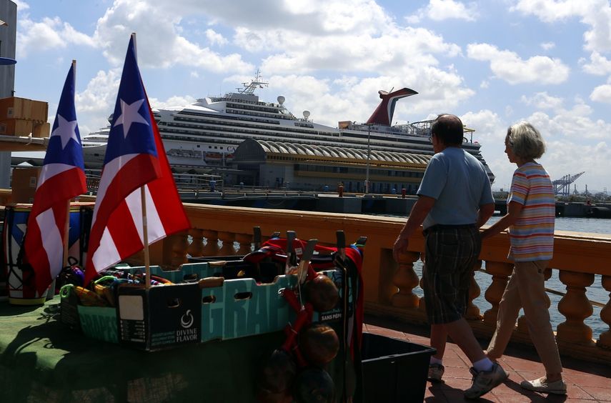 Dos turistas pasean frente a un crucero en el Puerto de San Juan, Puerto Rico.