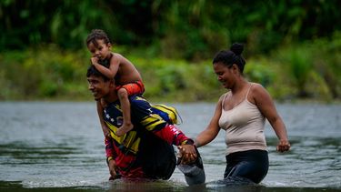 Migrantes venezolanos vadean el río Tuquesa tras cruzar a pie el Tapón del Darién, en Bajo Chiquito, Panamá, el 4 de octubre de 2023.