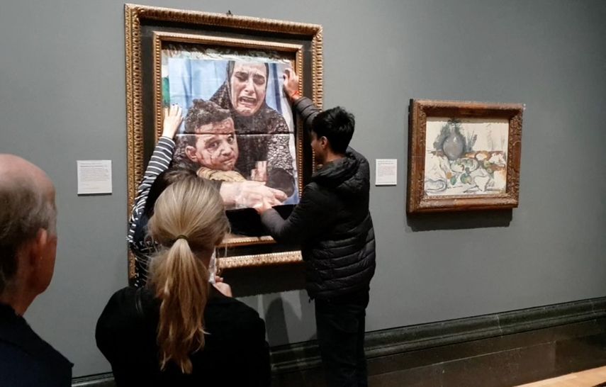 Una fotografía distribuida por el grupo de campaña Youth Demand muestra a un activista pegando una foto de una madre y un niño de Gaza sobre la obra de arte de Picasso titulada Maternidad, en la National Gallery en el centro de Londres el 9 de octubre de 2024.