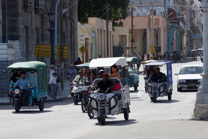 Personas se transportan abordo de triciclos eléctricos este martes en La Habana, Cuba.