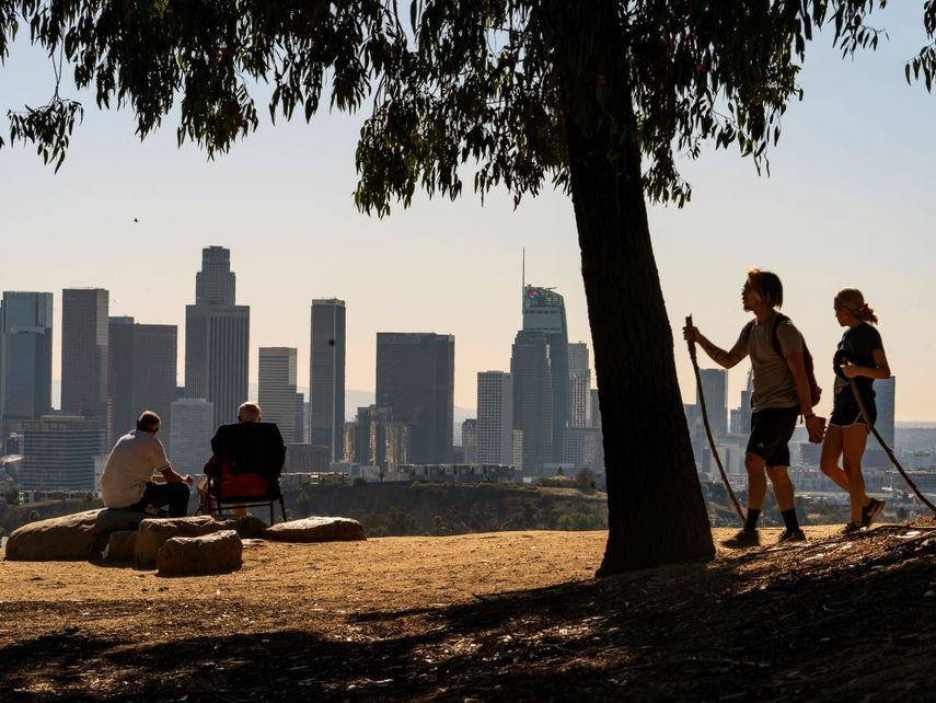 Fotografía de archivo del lunes 11 de enero de 2021 de Albert Maghbouleh, izquierda, y Miles Santamour, de la fundación Amigos de Jaibalito (ADJ), almorzando al aire libre con vista al horizonte de Los Ángeles.&nbsp;
