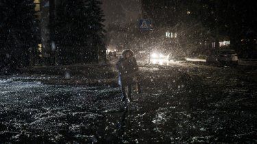 Una mujer cruza una calle durante una nevada, en pleno apagón en Kiev, Ucrania, el 16 de diciembre de 2022.&nbsp;