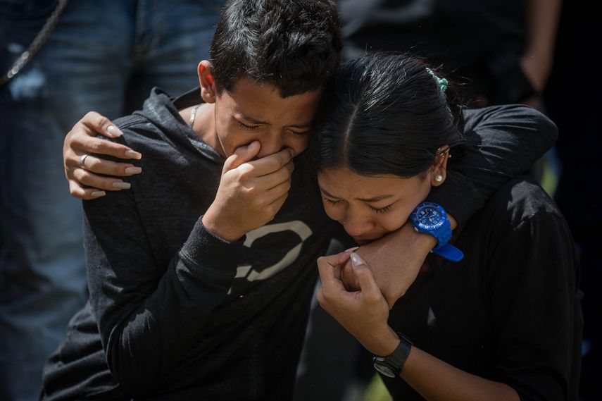 Familiares de José Díaz Pimentel y Abraham Agostini lloran en la parcela donde ambos fueron enterrados este sábado 20 de enero del 2018, en Caracas, Venezuela, por orden del régimen de Nicolás Maduro.