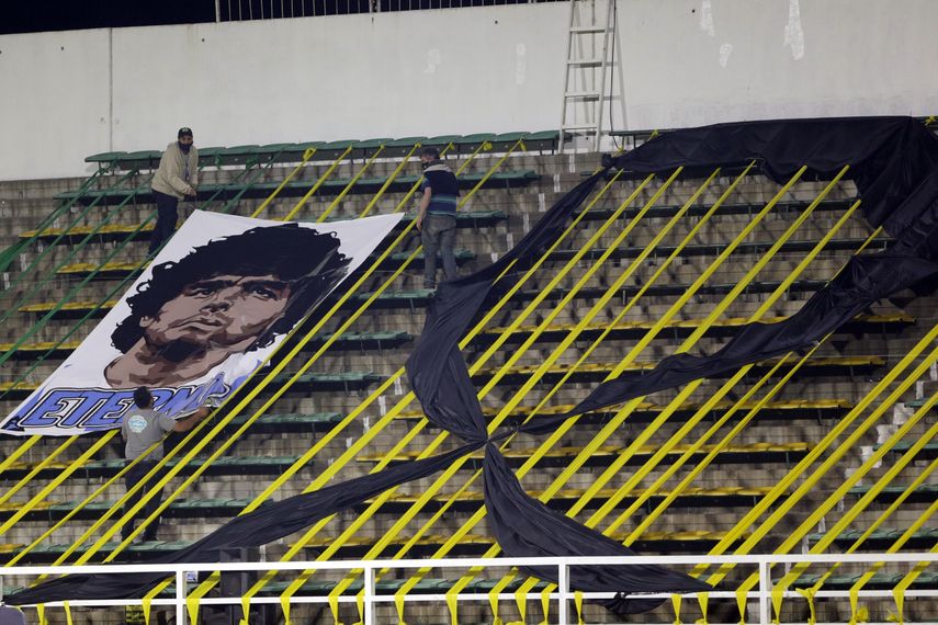Trabajadores instalan una pancarta con la imagen del fallecido Diego Armando Maradona en el estadio Norberto Tomaghello antes del partido por la Copa Sudamericana entre el argentino Defensa y Justicia y el brasileño Vasco Da Gama, en Buenos Aires, Argentina, el jueves 26 de noviembre de 2020.