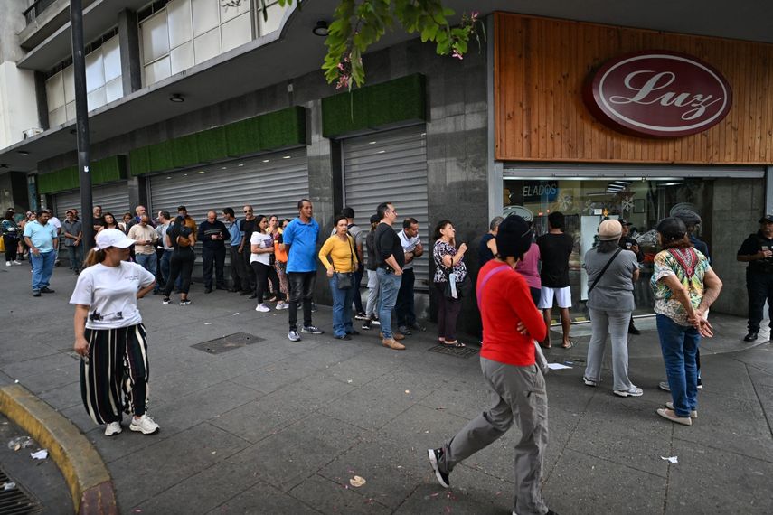 La gente hace fila frente a un supermercado en Caracas el 3 de enero de 2026, después de que las fuerzas estadounidenses capturaran al dictador venezolano Nicolás Maduro.