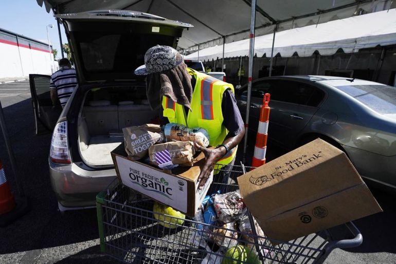 Voluntarios llenan carros de supermercado con alimentos para distribuirlos en el Banco de Alimentos St. Mary