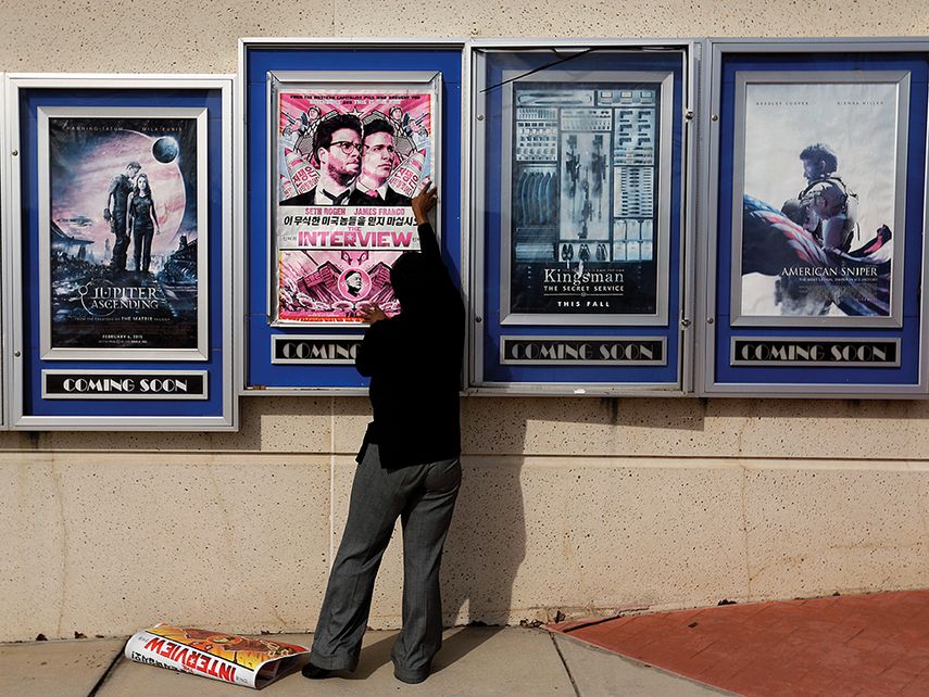 Un empleado retira el afiche que anuncia el debut de la cinta. (AP)