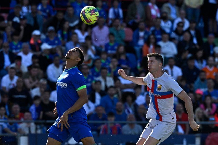 El atacante del Barcelona, Robert Lewandowski, pelea por el balón con el jugador del Getafe, Gastón Álvarez, durante el encuentro entre ambos clubes el 16 de abril de 2023.