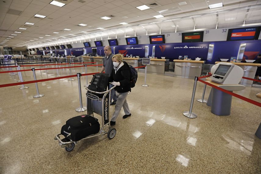 Los pasajeros Gisela Sánchez y Sael Sayago caminan desde el mostrador de Delta en el Aeropuerto Internacional de Salt Lake City. 